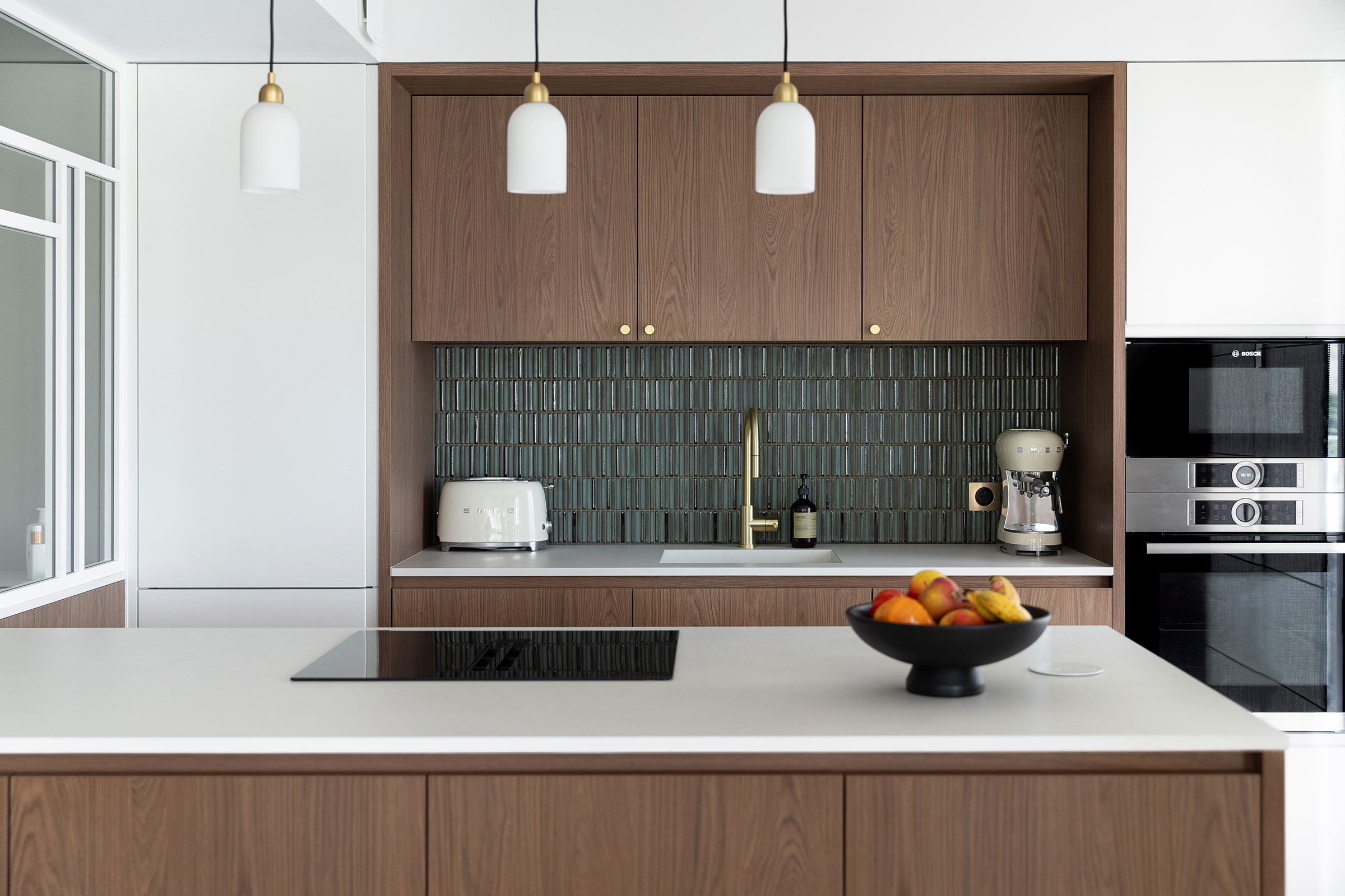 Cuisine sur mesure rénovée à Antibes avec îlot central en Dekton, façade bois, crédence en céramique texturée et électroménager encastré haut de gamme